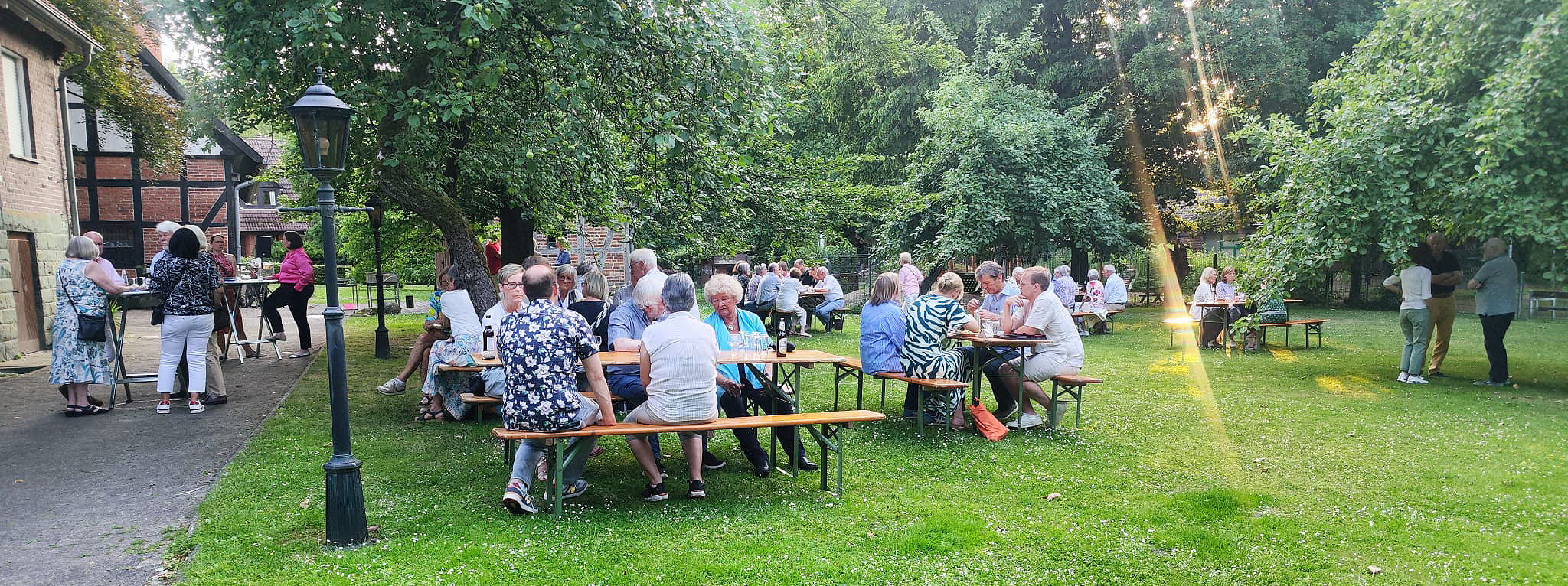 Sommerfest_Gruppe am Esstisch im Garten